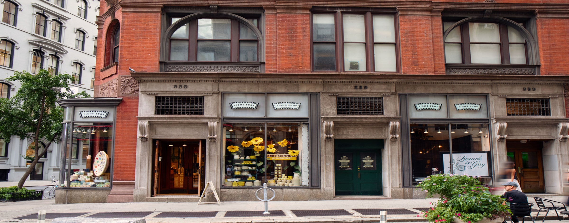 Neoclassical building facade with store entrances and decorative elements.