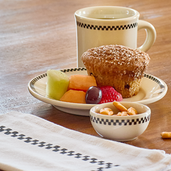 Muffin with fruit and a cup on a wooden table