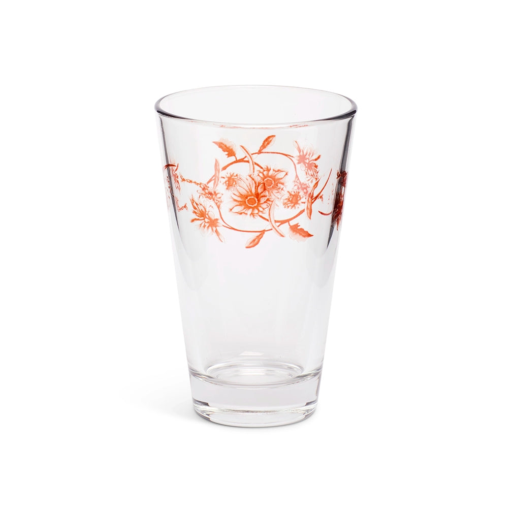 Orange floral juice glass at a slight angle showing the rim