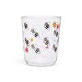 Clear juice glass with illustrated bumblebees on dotted flight paths and small flowers