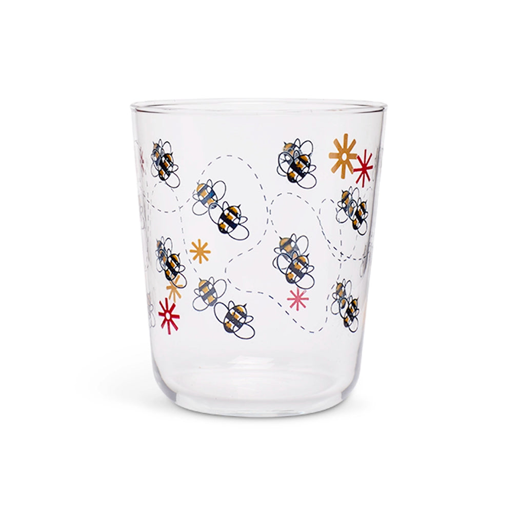 Clear juice glass with illustrated bumblebees on dotted flight paths and small flowers