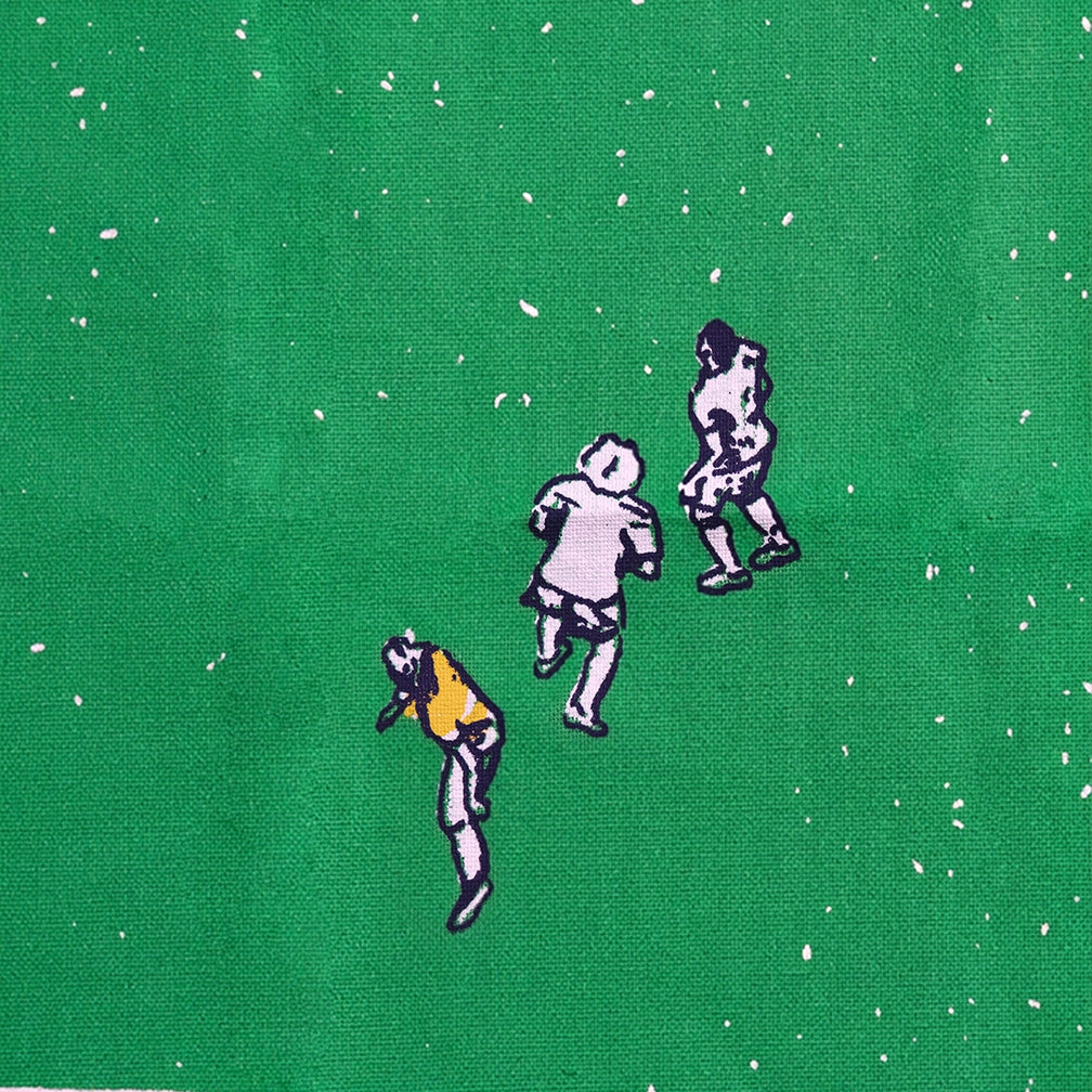 Close-up of soccer field tea towel showing illustrated players from above on green