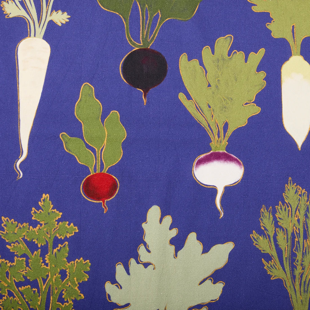Close-up of Root Down tea towel fabric with radishes, beets and leafy greens on royal blue