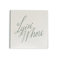White square matchbox from above with Lyin' Whore in green cursive script