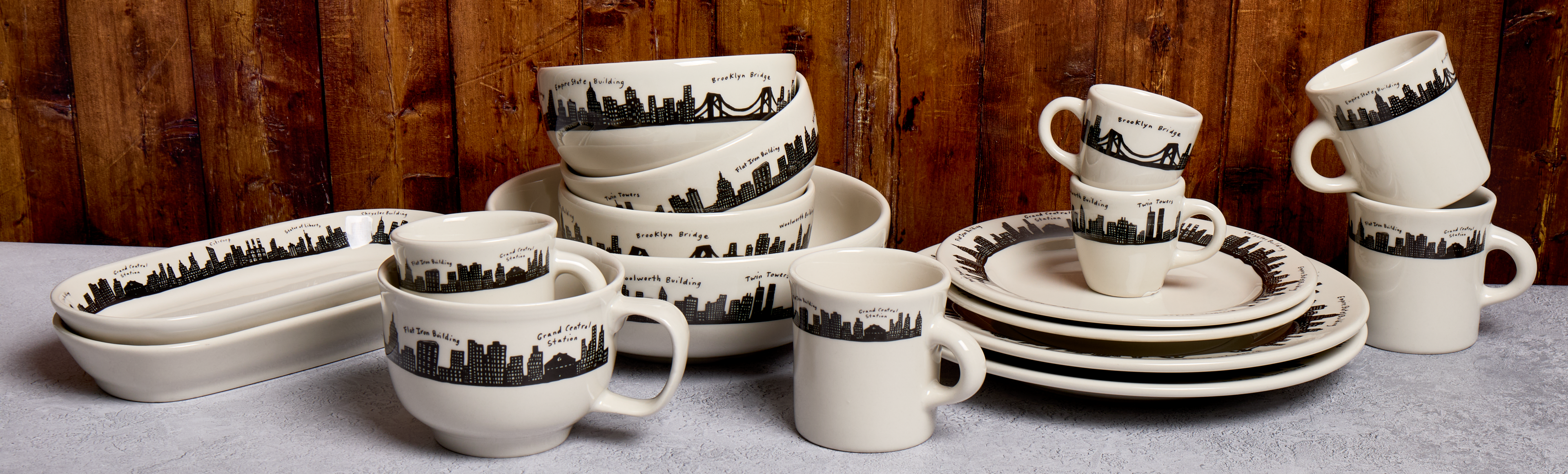 Set of ceramic dishes with black landscape patterns on a wooden background