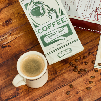 Coffee cup with a bag of coffee beans on a wooden surface