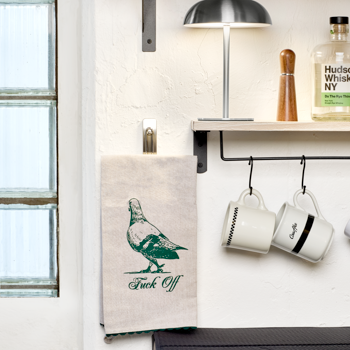 Kitchen scene with a towel, mugs, and a lamp on a shelf.