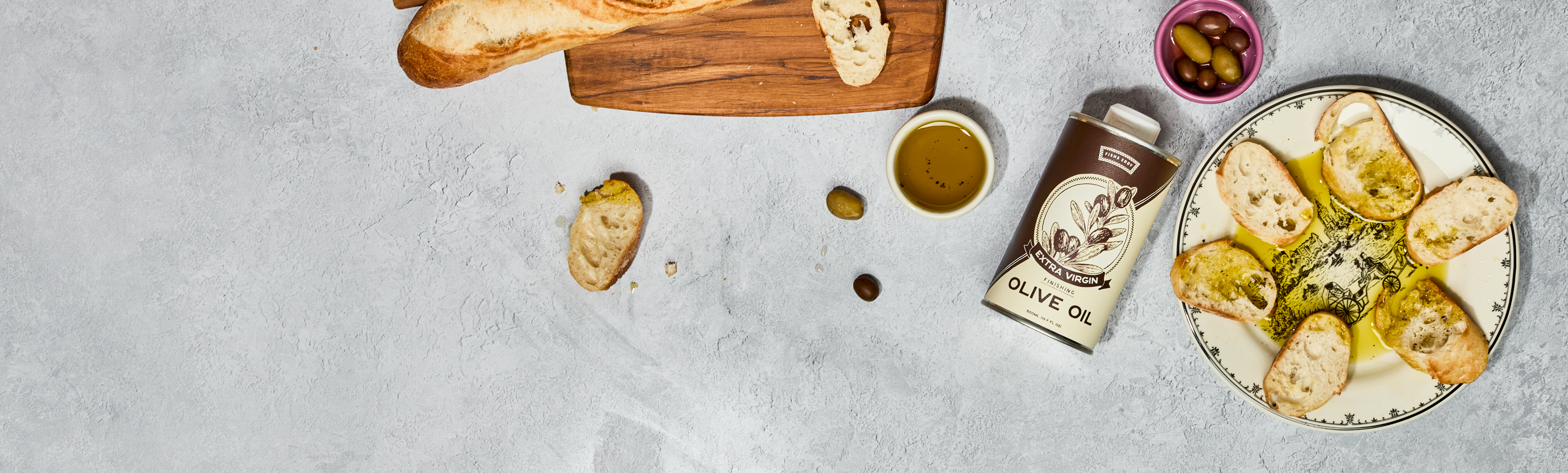 Platter of bread with olive oil and bruschetta on a textured surface