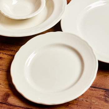 Set of white ceramic plates on a wooden surface
