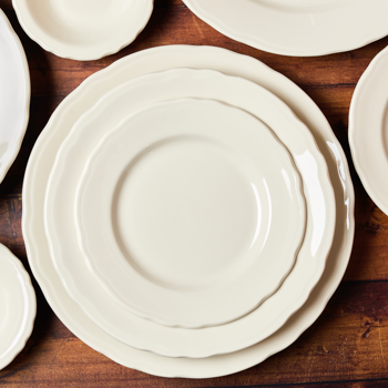 White ceramic plates stacked on a wooden surface