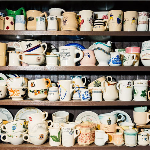 Shelves filled with a variety of colorful mugs and cups.
